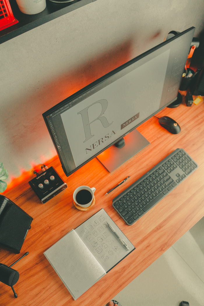 Top view of a stylish home office desk with coffee, computer, and accessories.