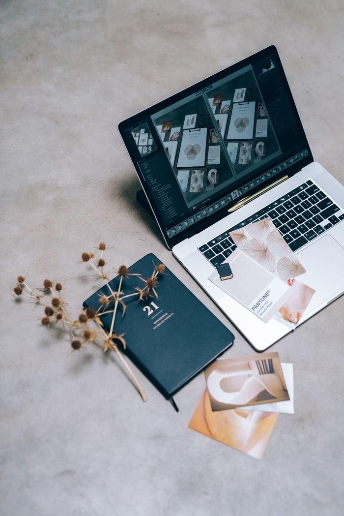 Mastering the First Impression: Your intriguing post title goes here A high-angle shot of a creative workspace featuring a laptop, planner, and dried flowers on a flat surface.